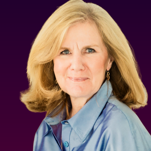 A portrait of Diane Dewhirst smiling who has blonde, mid-length hair and wears a blue shirt sits on a dark purple gradient background.